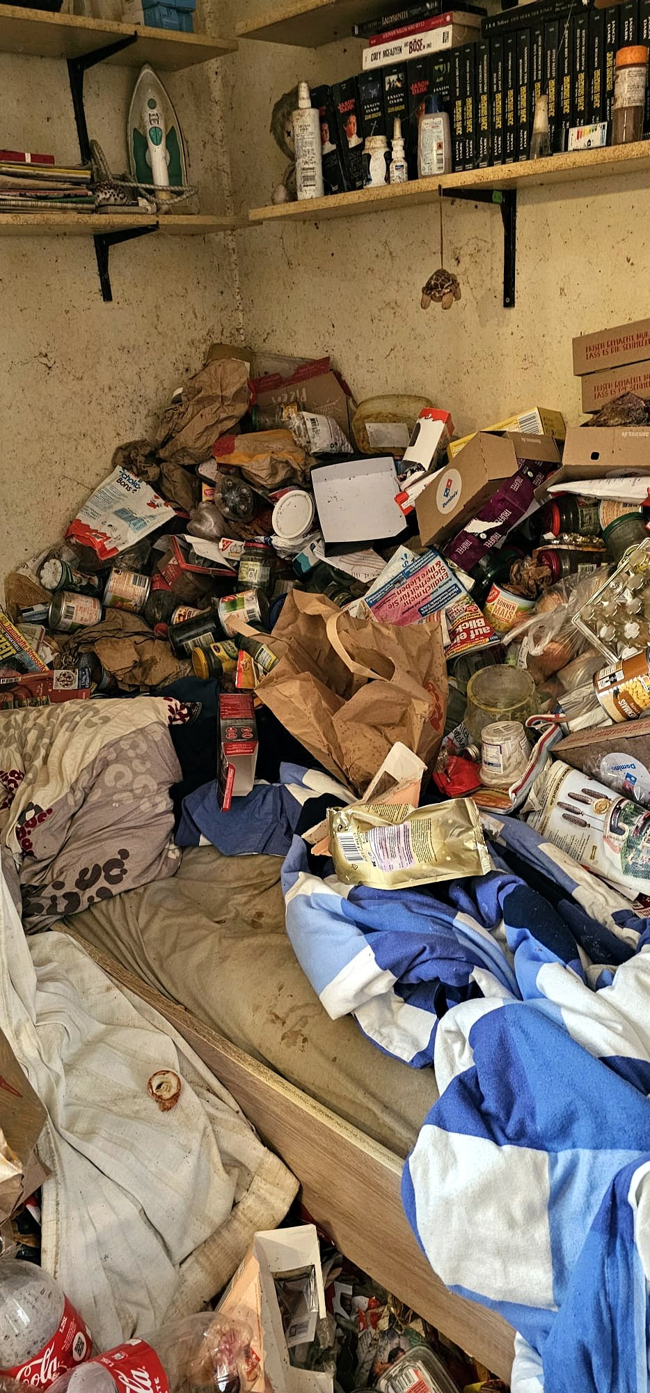Stark zugestelltes Schlafzimmer vor der Entrümpelung